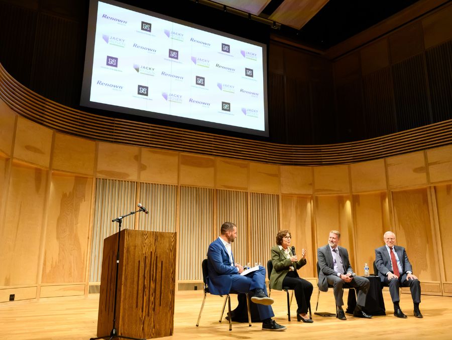 Group of four individuals sitting on stage for discussion.