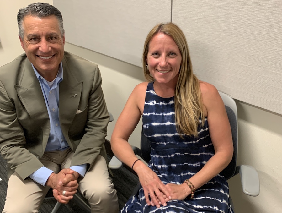 President Brian Sandoval sits next to Dr. Sarah Bisbing in the podcasting room at the Reynold's School of Journalism.