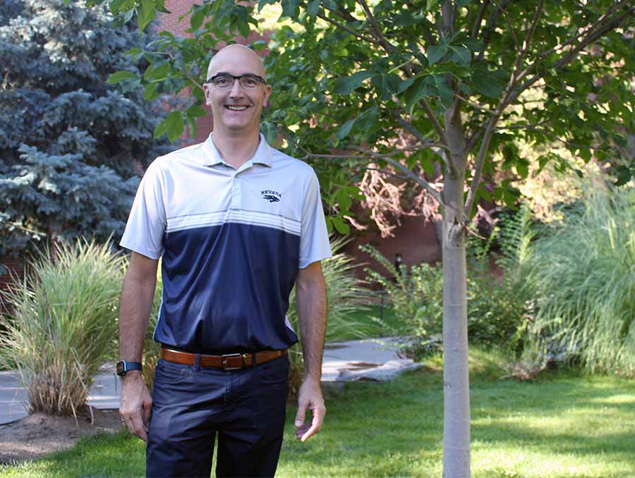 Eric Marchland standing outside wearing a Nevada polo.