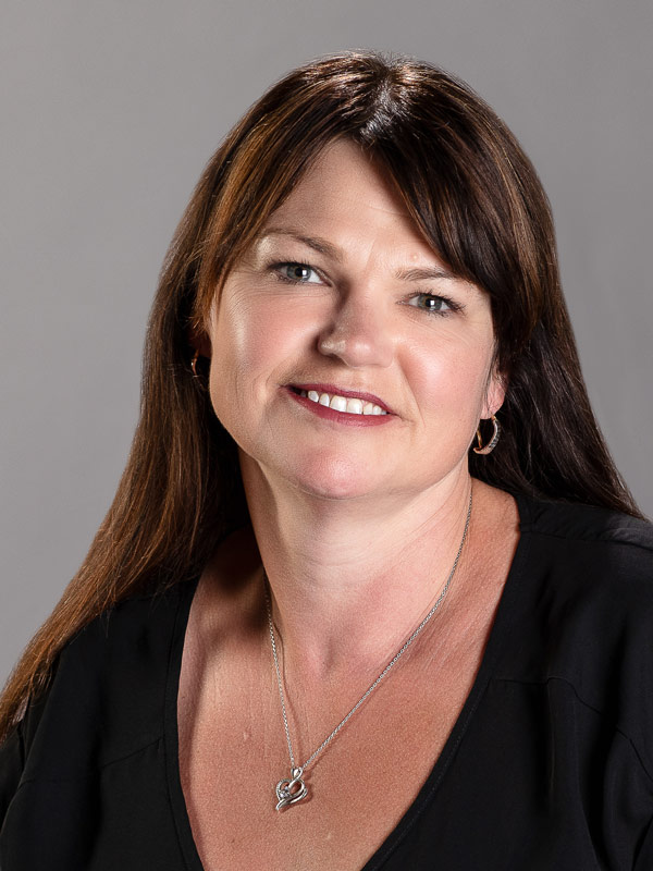 A portrait of Louisa Hope-Weeks, who is wearing a black shirt and smiling.