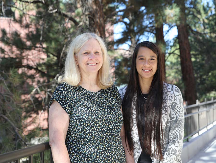 Chevonne Sutter, Ph.D., BCBA-D, and MaryAnn Demchak, Ph.D., BCBA-D, standing outside by trees