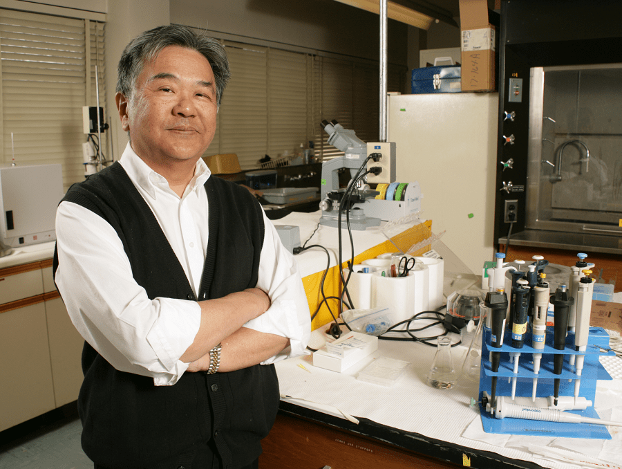 Stan Omaye stands arms crossed in his lab.