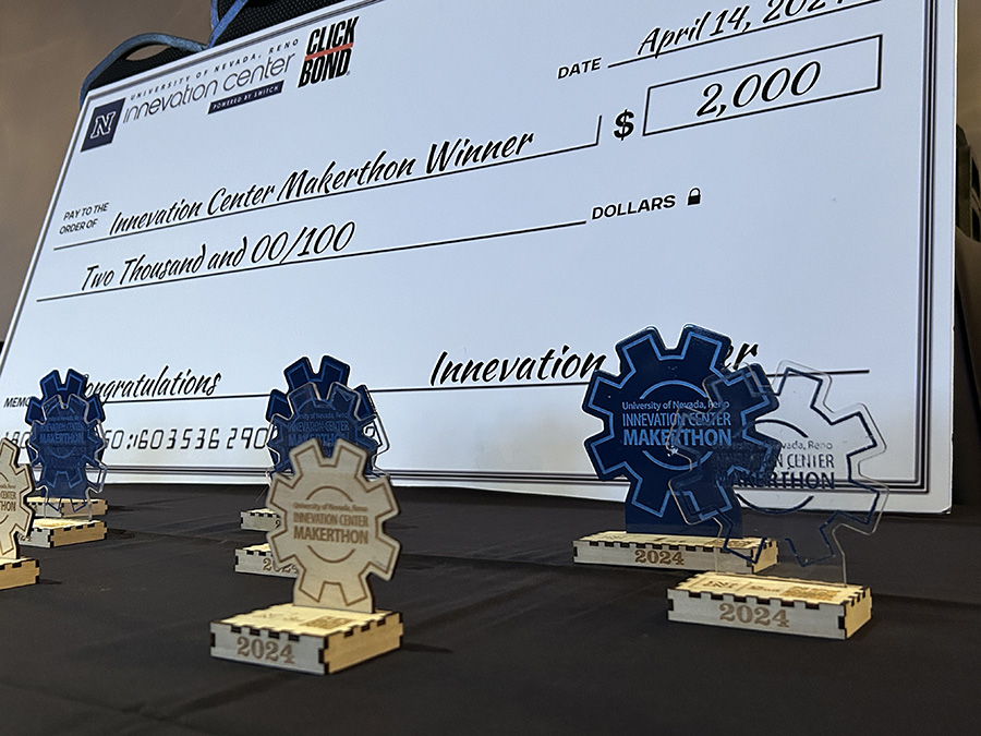 A large award check in the amount of $2,000 and cog-wheel trophies for the 2024 Makerthon competition.
