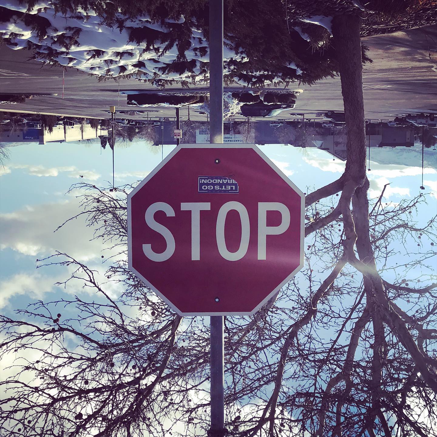 A stop sign hangs upside down at an intersection.