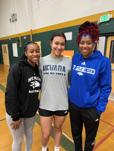 Women's Basketball players attend college pep rally in Sparks Middle School gym wearing Wolf Pack Basketball clothing.