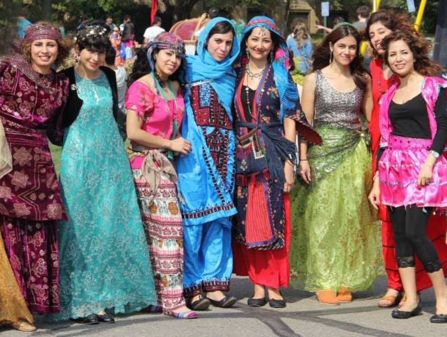 Seven smiling women wearing cultural clothing.
