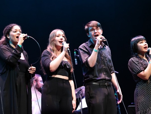 Four people singing.