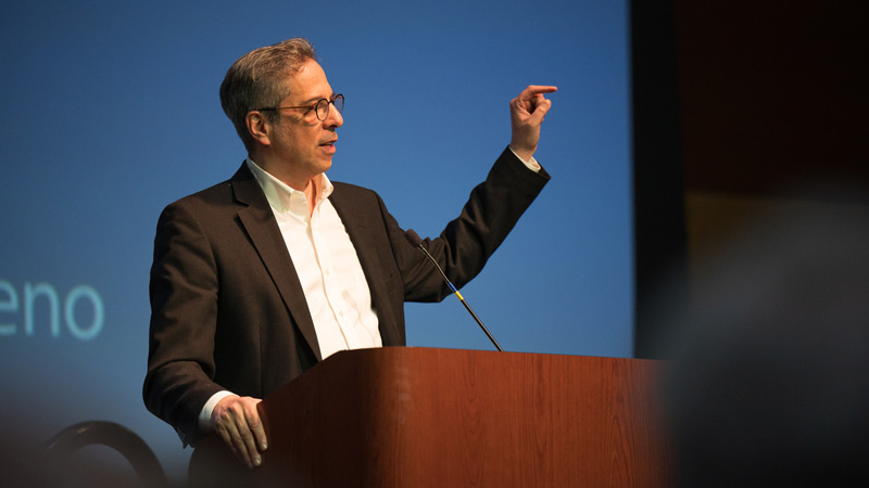 Steven Waldman speaking to the audience behind a podium