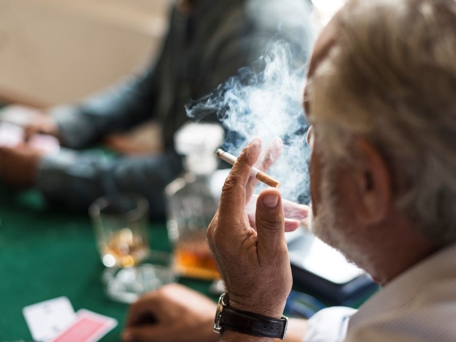 Man smokes at a casino table.