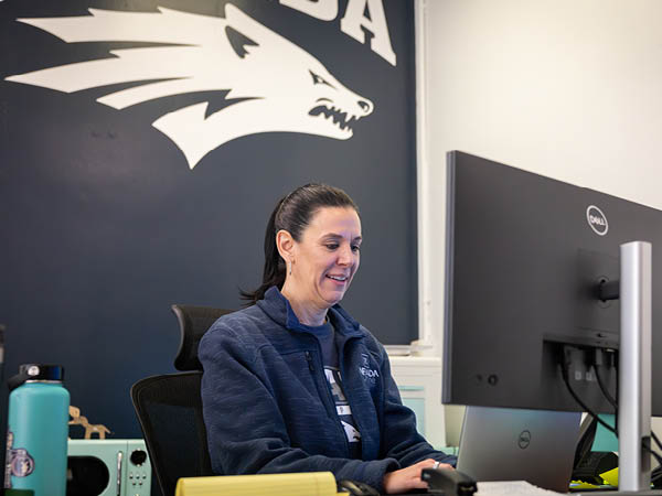 Carley Ries in her office, working on a computer at her desk.