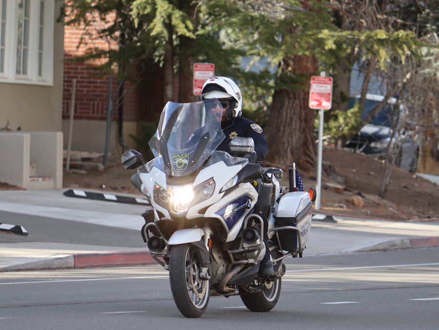 A police officer in uniform on a motorcycle on campus at the University.