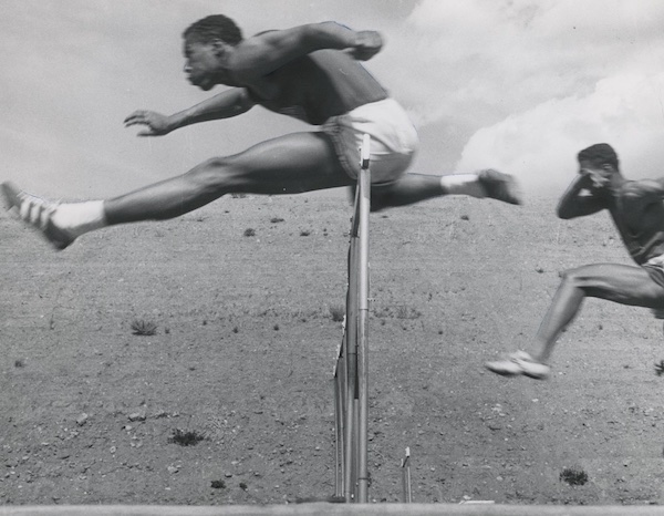 Otis Burrell in action as he jumps over a hurdle.