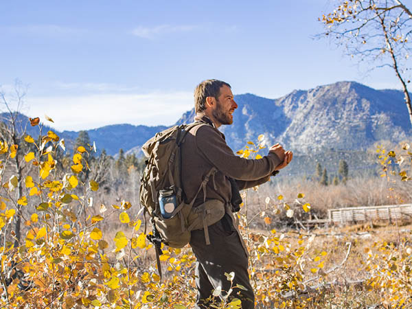 Chris Smith standing in front of a mountain landscape in the fall