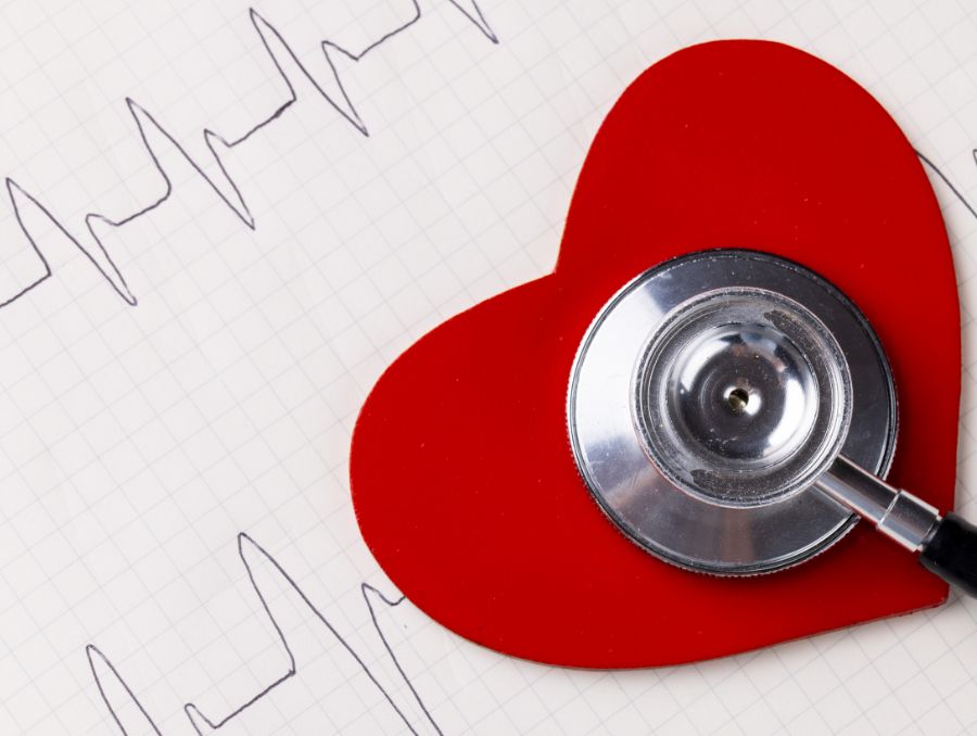 Image of red heart and stethoscope on white surface with heart rate