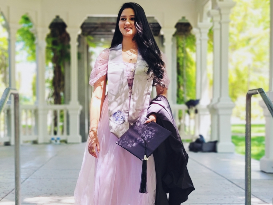 Kaashifah wearing wearing a graduation sash and holding her cap