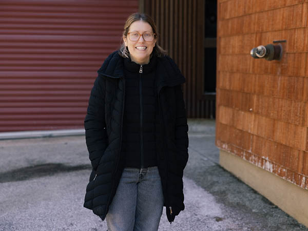 Faculty member Katherine Spinella standing outside the doors of the Garage Door Gallery on the Lake Tahoe campus.