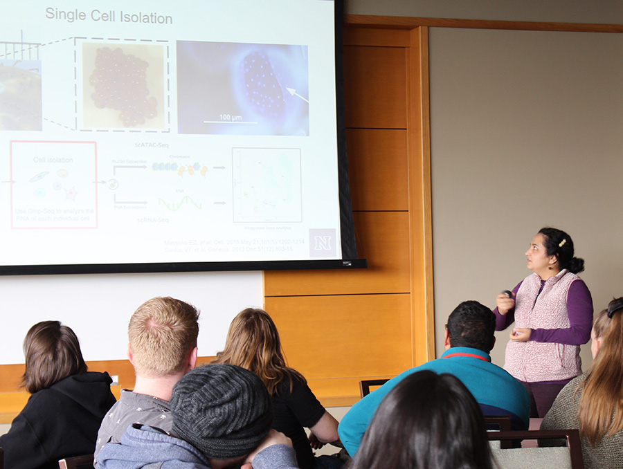 Person standing giving a presentation about single-cell research in front of attendees.