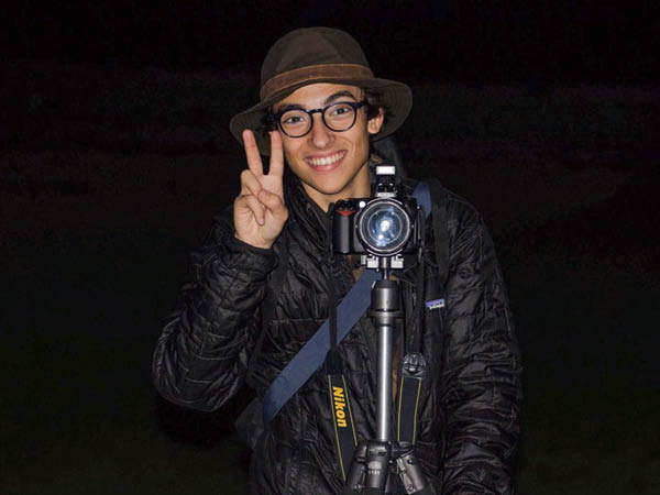 Pablo Agostini with a camera outside at night during an outdoor photoshoot.