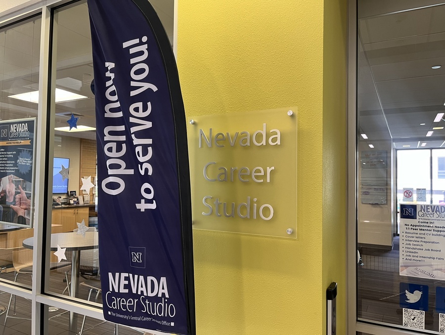 The Nevada Career Studio office on campus with a banner sign that reads “Open now to serve you!”