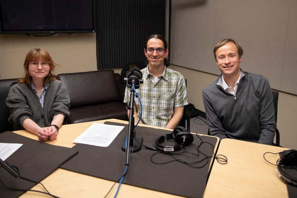 Maddie Lohman, Paul Hurtado, and Jevin West sit in a podcast studio in front of microphones.