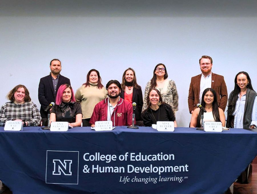 Panelist and committee members behind a table with the College's identifier