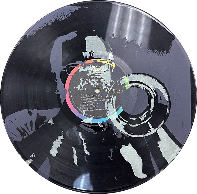 The sticker design incorporates a high-contrast image of the artist playing a trumpet silk-screened in gray and white over a photograph of a vinyl LP record.