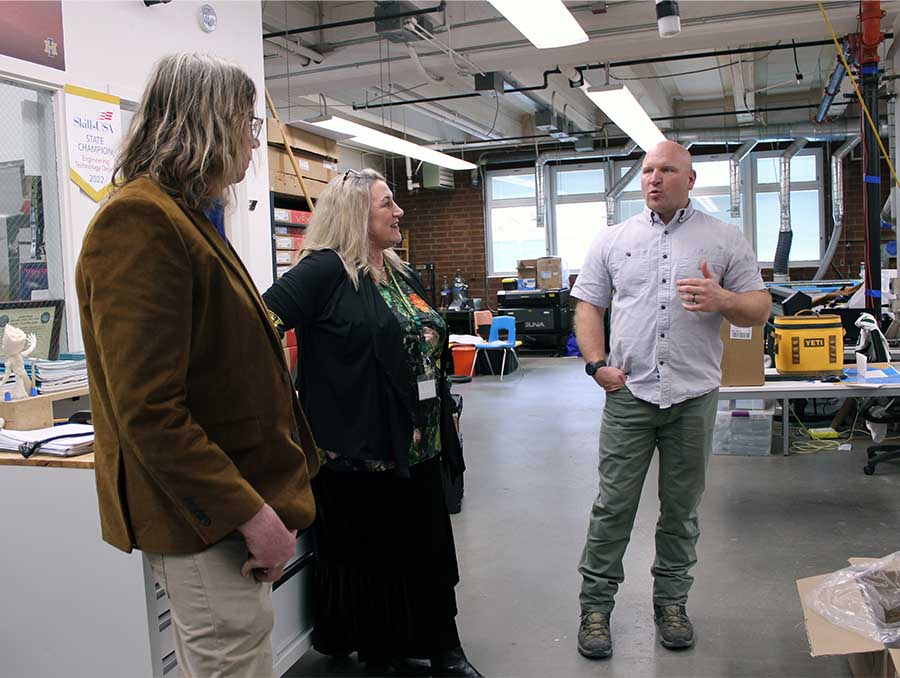 Three people standing in a lab space.