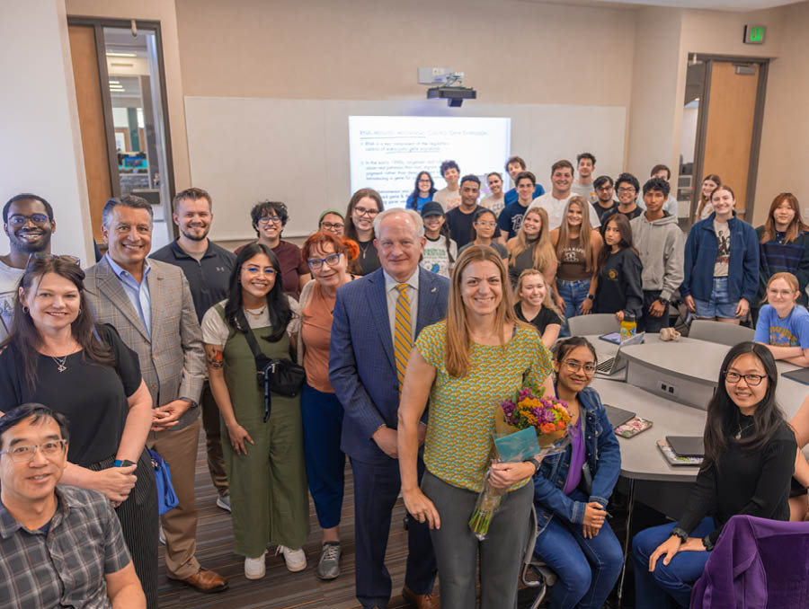 Pamela Sandstrom stands by Provost Jeff Thompson and President Brian Sandoval, alongside faculty, colleagues, and students from the College of Science.