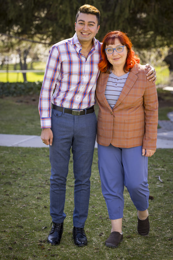 Muhammad stands next to his mentor Elena outside on the quad.