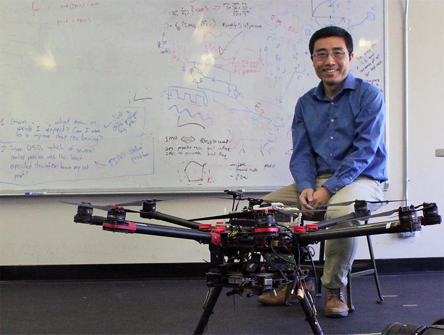 Hao Xu sits behind a drone in his lab.
