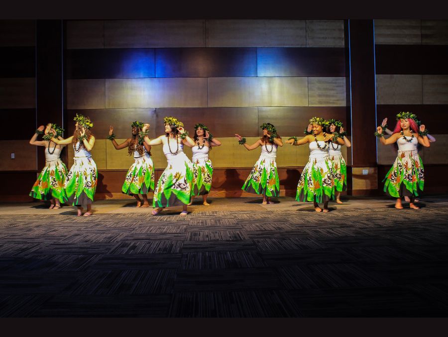 Club members dancing in traditional outfits on stage.