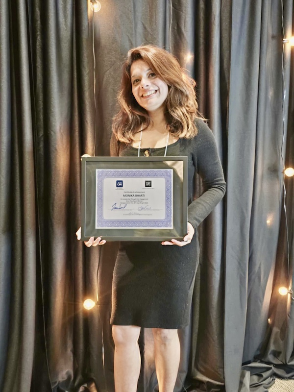 Monika holding a certificate.