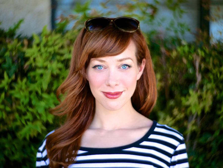 A photo of a woman in a striped shirt smiling into the camera.