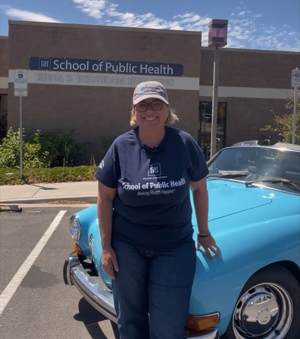 Muge Akpinar-Elci, Dean of the School of Public Health, standing in front of a classic car