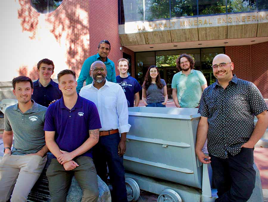 Nine people stand in front of the Laxalt Mining Engineering Building on the University of Nevada, Reno campus.