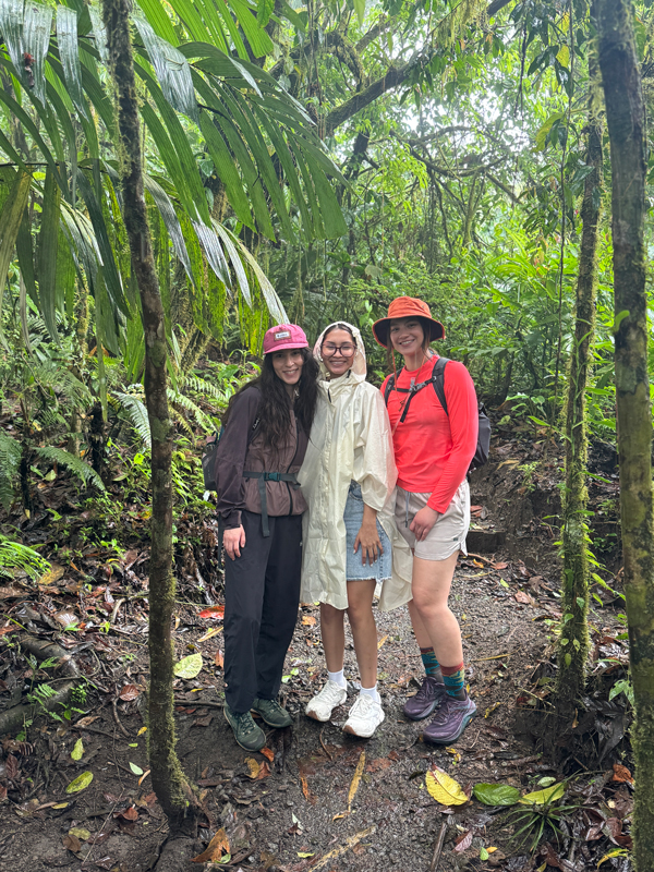Students in a damp jungle in Costa Rica surrounded by trees. 