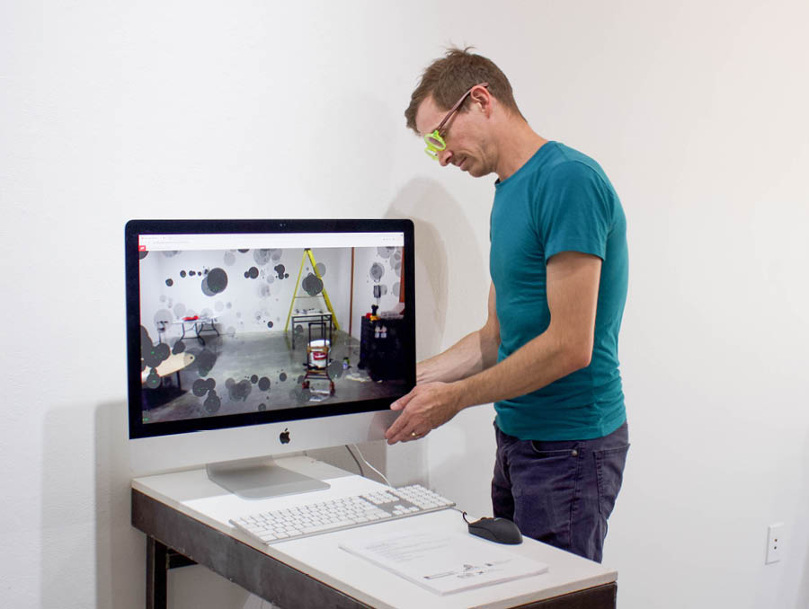 Calkin setting up his piece that projects smoke on top of viewers on a computer screen.