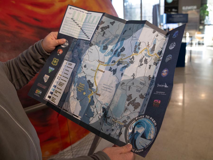 A person holds a map at the entrance to the Fleischmann Planetarium.