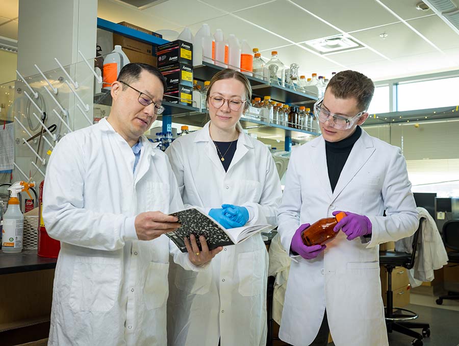 Dr. Lee, Hannah Schultz and Riley Gillis reviewing laboratory notes.&nbsp;