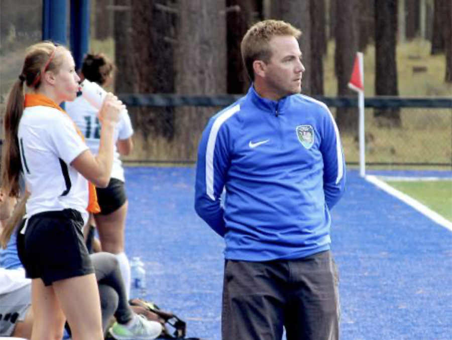 Jeremy Evans stands on the sidelines of a soccer match.