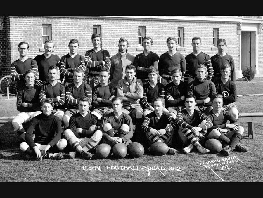 Black and white film photo of the University of Nevada Football Squad; Title taken from image. A caption handwritten on the image reads, "U of N Football Squad, 1912, T. C. Wohlbruck Reno Nev XII"