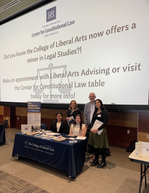 Students at a tabling event showcasing signage for the new minor in legal studies.