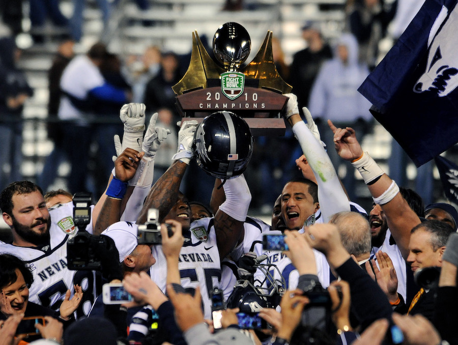 The 2010 Nevada Football team holds up the 2010 Champions football trophy triumphantly.