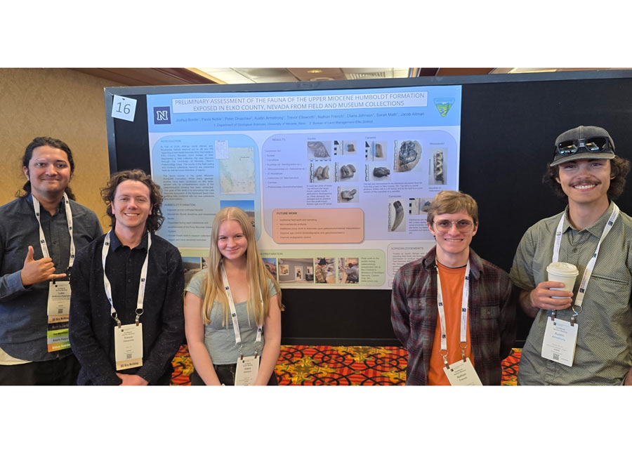 Five students smile in front of a research poster.