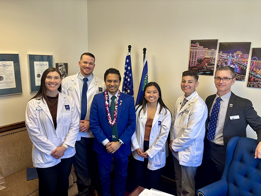 PA students wearing white coats advocating with legislators at the State Capital.