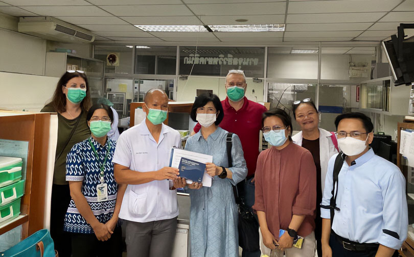 Paul Brett and Mary Burtnick meet with healthcare professionals during a visit to Mukdahan Hospital in northeastern Thailand to support infectious disease research and collaboration.