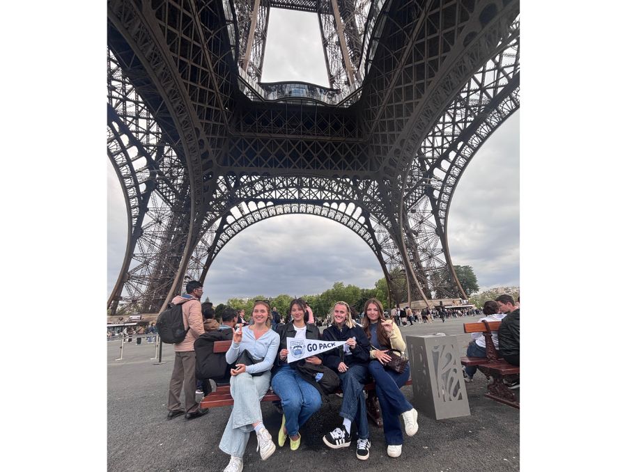 A group of students sitting under the Eiffel Tower.