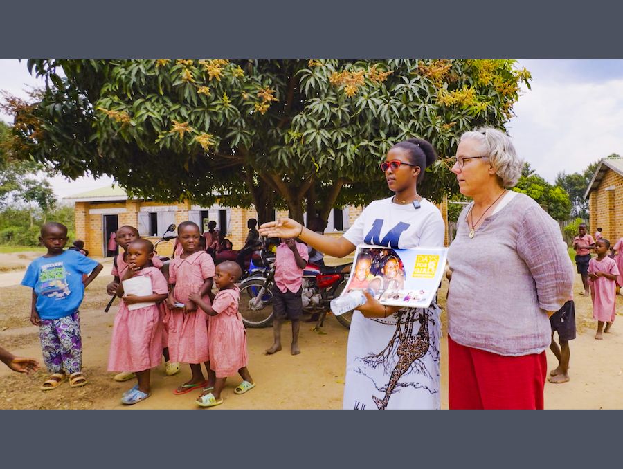 Deb in Uganda working with a woman and a group of children.