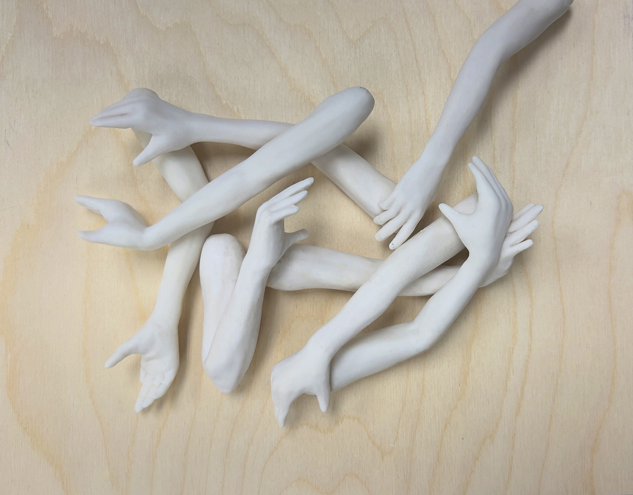An art display of ceramic hands intertwined. 