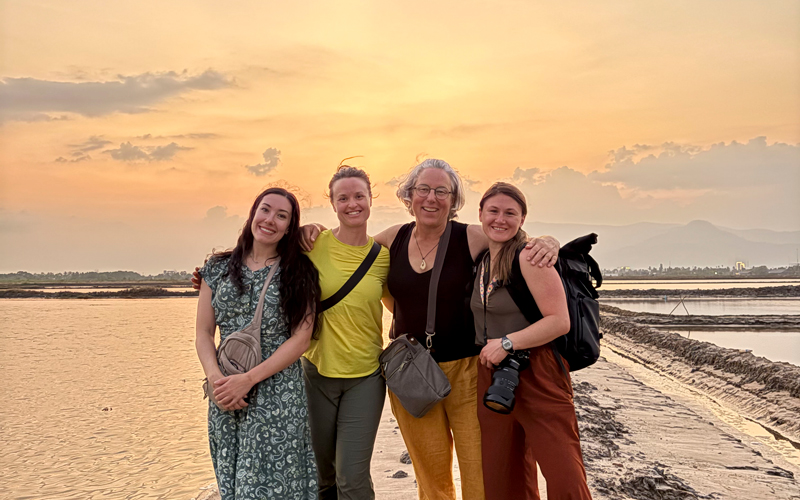 Members of the nursing school and Kat Fulwider on the salt flats with a colorful sunset behind them.